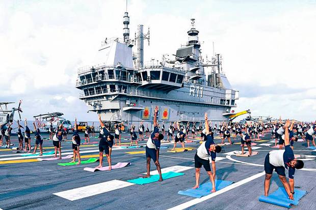 **EDS: IMAGE VIA @IN_R11Vikrant** Indian Ocean: Team R11 personnel do yoga on INS Vikrant ahead of the International Yoga Day, at sea. (PTI Photo)