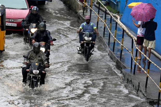 Chennai: Motorcyclists drive past the waterlogged Rajiv Gandhi IT Expressway after rainfall, in Chennai. (PTI Photo)