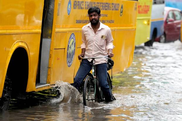 Chennai: A cyclist rides past the waterlogged Rajiv Gandhi IT Expressway after rainfall, in Chennai. (PTI Photo)