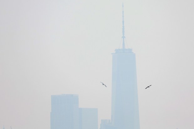 The One World Trade Center tower in lower Manhattan is shrouded in haze and smoke which drifted south from wildfires in Canada, in New York City. (Image: REUTERS/Mike Segar)