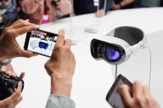 People use phones as Apple's Vision Pro headset is on display at Apple's annual Worldwide Developers Conference at the company's headquarters. (Image: REUTERS)