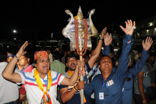 Pilgrims shout religious slogans while boarding a bus as the first batch of pilgrims leaves for the Amarnath Yatra 2023 in Jammu. (Image: PTI)