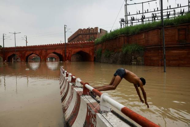 A man dives in a flooded road behind Red Fort, after a rise in the waters of river Yamuna due to heavy monsoon rains, in New Delhi. REUTERS