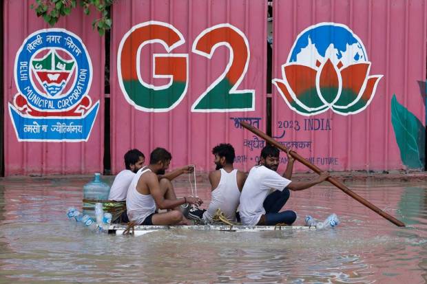 People ride on a boat on a flooded road, after a rise in the waters of river Yamuna due to heavy monsoon rains, in New Delhi. REUTERS