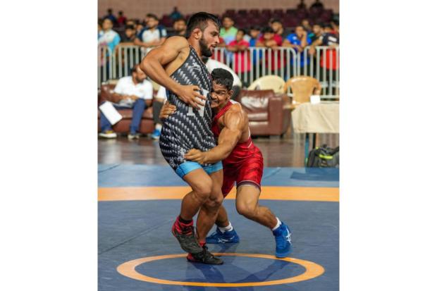 Praveen (in red) of Maharashtra and Vijay of Haryana compete in the men's 60kg category event during the Asian Games 2023 wrestling trials.