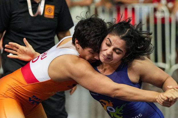 Anshu Malik (in orange) of Haryana and Sarita of RSPB compete in the women's 57kg category event during the Asian Games 2023 wrestling trials.