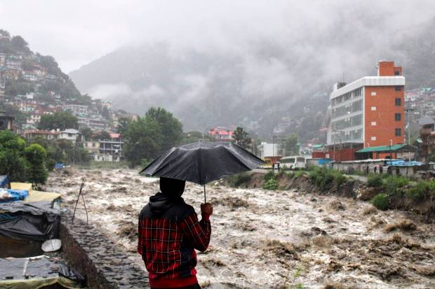 A man looks at a swollen Beas River following heavy rains in Kullu, Himachal Pradesh, India.(AP Photo)