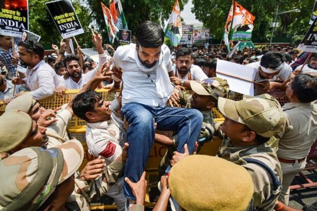 A member of Indian Youth Congress (IYC) crosses a police barricade during a protest in New Delhi on July 20. (Image: PTI)