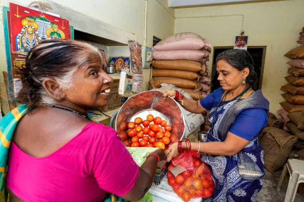 A staff at a fair price shop sells tomatoes, in Chennai, TN (PTI)
