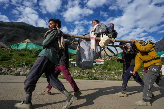Baltal: Porters carry an Amarnath yatri on a palanquin to the shrine temple from the base camp, in Baltal. (PTI Photo)