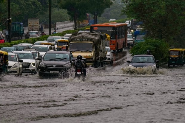 Traffic moves at a slow pace on a waterlogged road following heavy monsoon rains, at Ring Road in New Delhi on July 8, 2023. (Image: PTI Photo/Manvernder Vashist Lav)