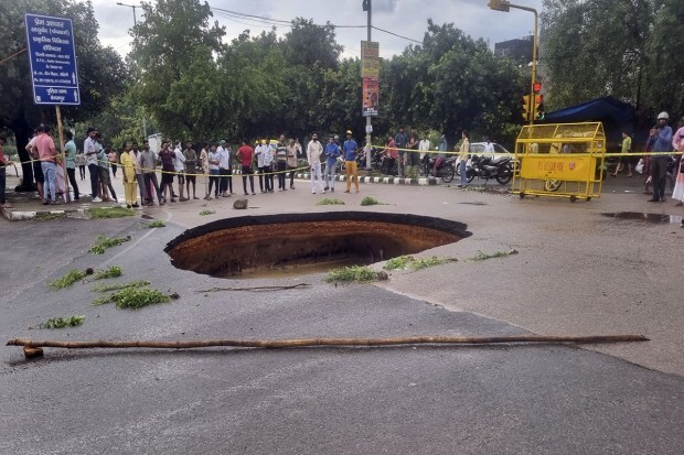 A crater is formed after a road caved in after heavy monsoon rains, at Rohini in New Delhi on July 9, 2023. (Image: PTI Photo)