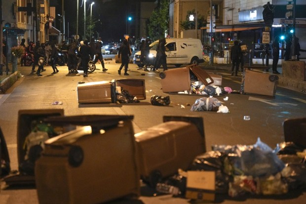 Protesters block a street with garbage cans in Colombes, outside Paris, France on July 1, 2023. French President Emmanuel Macron urged parents Friday to keep teenagers at home and proposed restrictions on social media to quell rioting spreading across France over the fatal police shooting of a 17-year-old driver. (Image: AP/Lewis Joly)