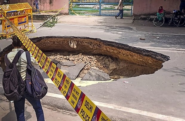 A crater is formed after a road caved-in at Janakpuri, in New Delhi (Image: PTI Photo)