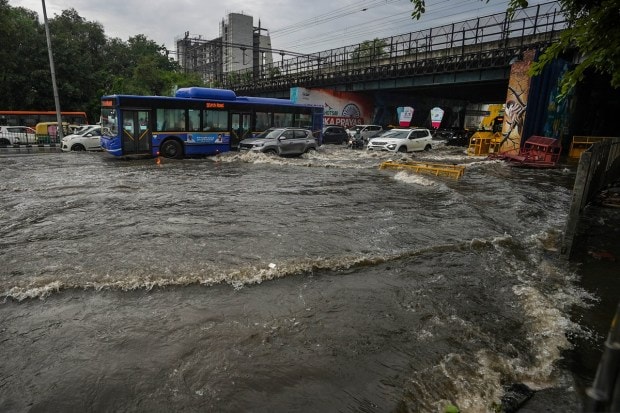 Vehicles make their way on a waterlogged road following monsoon rains near Tilak Bridge, ITO, in New Delhi on July 9, 2023. (Image: PTI Photo/Manvernder Vashist Lav)