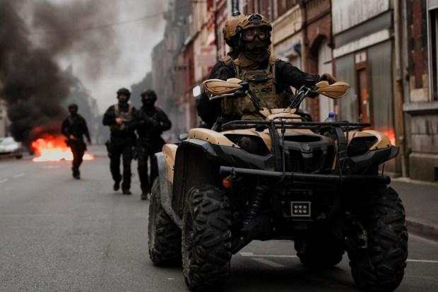 Officers ride a vehicle during riots following the death of Nahel in France. (Image: Reuters/Nacho Doce)