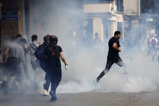Youths run away during a protest in Strasbourg, eastern France. (Image: AP Photo/Jean-Francois Badias)