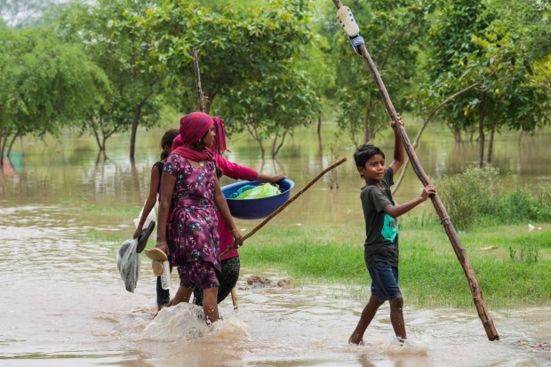 People from low-lying areas around the Yamuna river carry their belongings while relocating to a safer place. (Image: PTI)