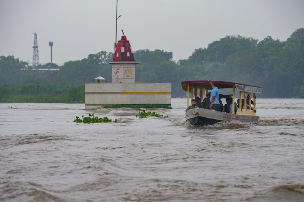 People take ride on a boat in Yamuna river after heavy monsoon rains in New Delhi. (Image: PTI)