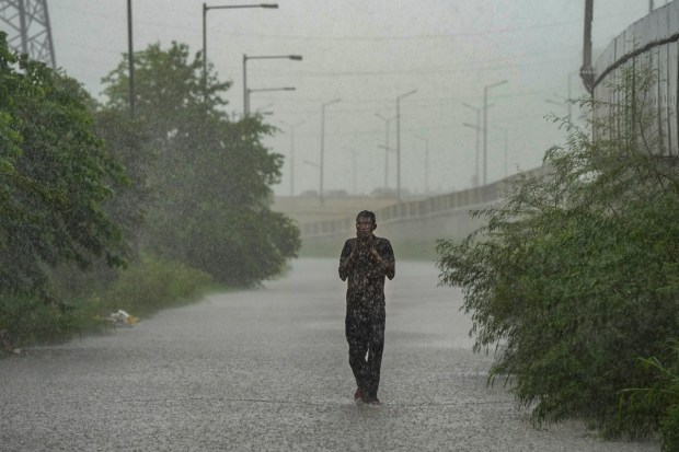 A man caught in heavy rain in New Delhi. (Image: PTI)