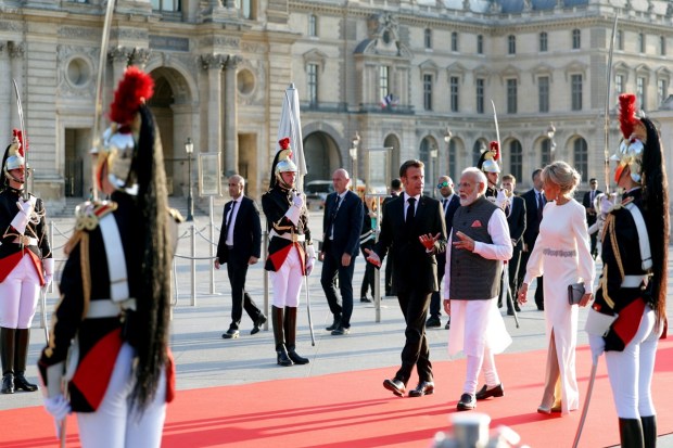 Prime Minister Narendra Modi with French President Emmanuel Macron and his wife Brigitte Macron arrive for a State Banquet at the Louvre Museum, in Paris on July 14. (Image: PTI Photo)