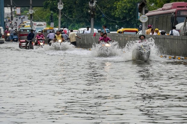 Vehicles move on a waterlogged road as the swollen Yamuna river inundates nearby areas, at ITO in New Delhi on July 15, 2023. (Image: PTI Photo/Kamal Singh)