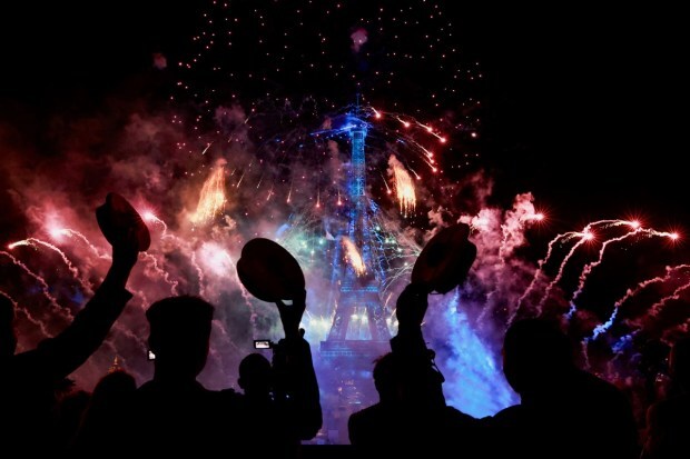 People watch as fireworks explode around the Eiffel Tower during celebrations to mark the fetivities. (REUTERS/Pascal Rossignol)