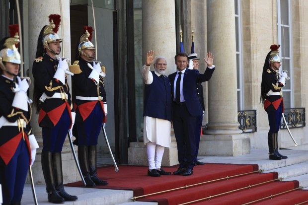 PM Modi and French President Emmanuel Macron wave before their talks at the Elysee Palace in Paris on July 14, 2023. (Image: AP Photo/Aurelien Morissard)