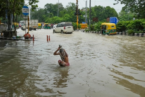 A man bathes in floodwater near Shanti Van as the swollen Yamuna river inundates nearby areas, on July 15, 2023. (Image: PTI Photo/Kamal Singh)