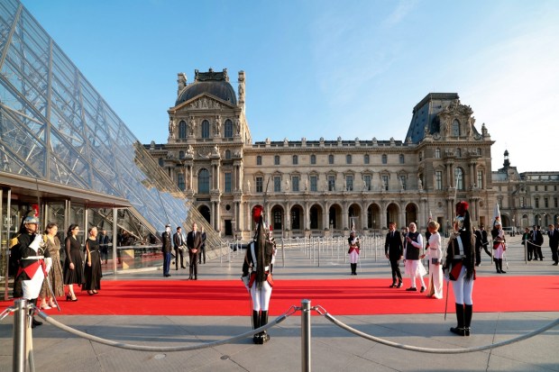 Prime Minister Narendra Modi with the French President Emmanuel Macron and his wife Brigitte Macron arrives for a State Banquet at the Louvre Museum, in Paris. (Image: PTI Photo)