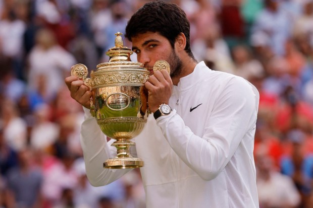 Alcaraz kisses his first Wimbledon trophy. (Image: Reuters)