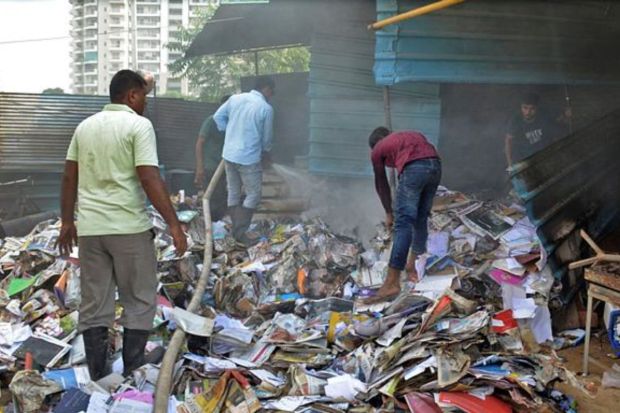 People search through the rubble of a scrap shop that was vandalised by a mob. The aggressive mobs vandalised and torched shops and restaurants in Badshahpur, Pataudi Chowk, and Sector 67 after the mosque was burned down in Sector 57. (Photo Credits: Reuters) 