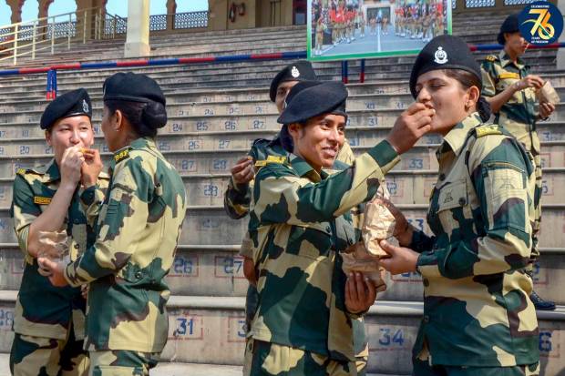 Border Security Force (BSF) personnel offer sweets to each other after a flag hoisting ceremony on the occasion of the 77th Independence Day, at the India-Pakistan Attari-Wagah border post near Amritsar. (PTI Photo)