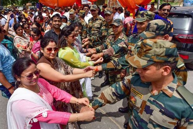 Women tie 'rakhis' on the wrists of Army personnel to celebrate Raksha Bandhan festival, in Prayagraj. (PTI Photo)
