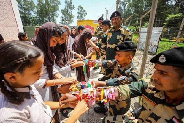 Schoolgirls tie 'rakhi' to Border Security Force (BSF) personnel on 'Raksha Bandhan', near the India-Pakistan Border at Suchetgarh about 35 km from Jammu. (PTI Photo) 