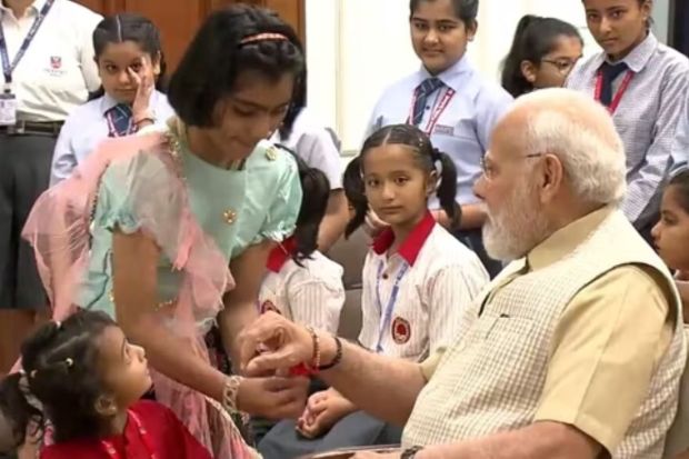 School girls tie rakhi on Prime Minister Narendra Modi’s wrist on August 30 in Delhi as they celebrated the festival of Raksha Bandhan with him. (ANI Photo)