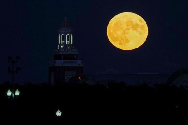 The blue supermoon rises behind Navy Pier Auditorium, Wednesday, Aug. 30, 2023, in Chicago. The cosmic curtain rose Wednesday night with the second full moon of the month, the reason it is considered blue. It's dubbed a supermoon because it's closer to Earth than usual, appearing especially big and bright. (AP Photo/Kiichiro Sato)