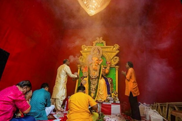 Priests and devotees offer prayers to Lord Ganesha at a community puja pandal on the occasion of Ganesh Chaturthi festival in Kolkata. (Image: PTI)