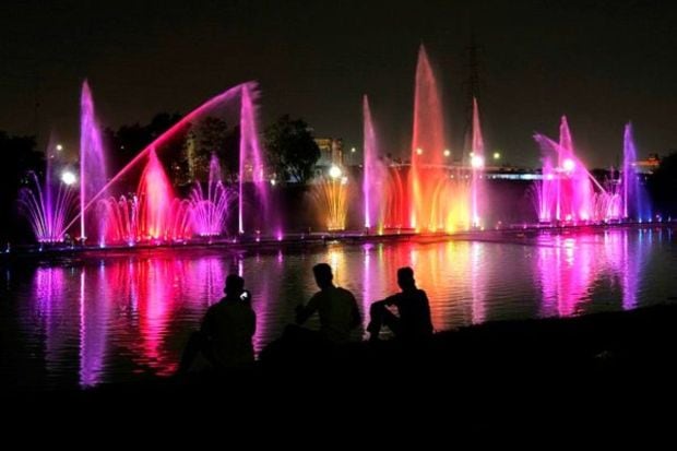 People watch a test run of a musical fountain constructed near the banks of the river Yamuna for the G20 Summit, in New Delhi, India, Friday, Aug. 25, 2023. The musical fountain at Baansera Park will display lotus patterns and the logo of the G20 Summit. (AP Photo/Manish Swarup)