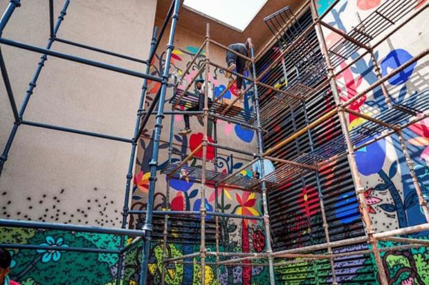 An artist paints graffiti at the Mandi House metro station ahead of the G20 Summit. (PTI Photo/Manvender Vashist Lav)