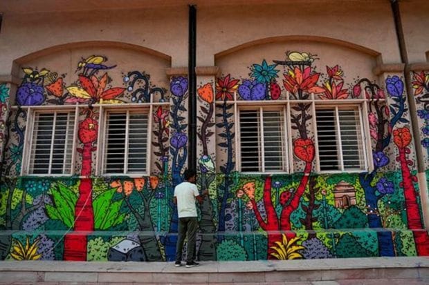 An artist paints graffiti at the Mandi House metro station ahead of the G20 Summit. (PTI Photo/Manvender Vashist Lav)