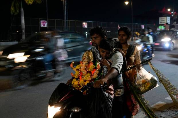 Devotees on a motorcycle arrive with an Idol of elephant-headed Hindu god Ganesha to immerse the same in Hussain Sagar Lake after worship during the Ganesh Chaturthi festival in Hyderabad. (AP Photo)