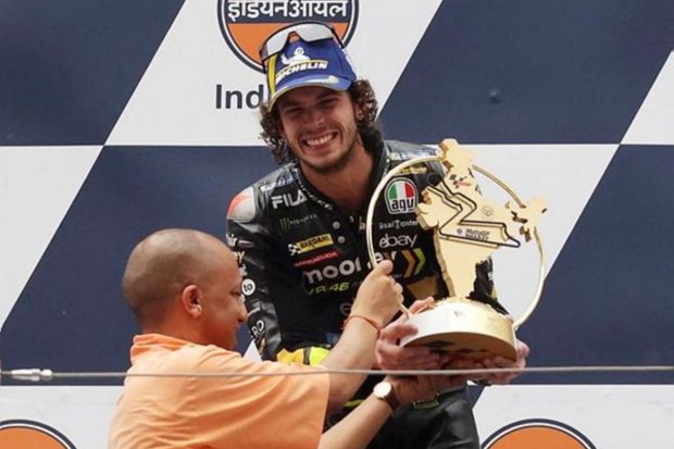 UP CM Adityanath hands Italy's Marco Bezzecchi the trophy on the podium after he wins the MotoGP. (Image: Reuters)