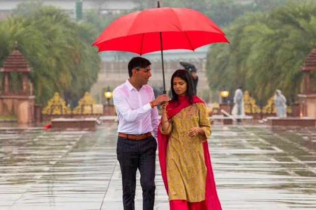 The couple shared an umbrella while walking inside the premises of the Akshardham Temple as it rained in Delhi-NCR. (Image: PTI)