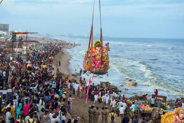 Devotees use a crane to immerse a Lord Ganesha idol at the Pattinapakkam beach during Ganesh festival, in Chennai. (PTI Photo)