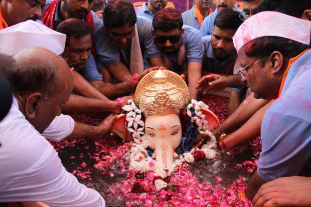 Devotees immerse an idol of Lord Ganesha during the Ganesh Chaturthi celebration, in Gurugram. (PTI Photo)