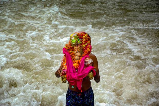A devotee immerses an idol of Lord Ganesha into a canal as part of Ganesh Chaturthi festivities, in Amritsar. (PTI Photo)