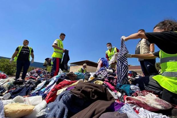 Volunteers from the Beltrees Youth Movement sort clothes that are to be distributed to the displaced people, in the aftermath of the floods in Derna. Marie el-Drese, the aid group's secretary-general, told that a further 10,100 people are reported missing in the Mediterranean city. Health authorities previously put the death toll in Derna at 5,500. (REUTERS/Esam Omran Al-Fetori)