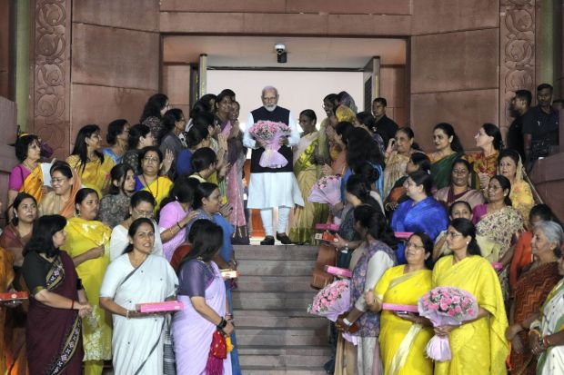 Prime Minister in group photograph with Union Minister Smriti Irani and women MPs. Women members from both Houses of Parliament, including PT Usha, and Union Ministers Meenakashi Lekhi and Smriti Irani, were all smiles as they presented a bouquet to Prime Minister Modi on the historic passage of the Bill in Parliament. (PTI Photo/Manvender Vashist Lav) 