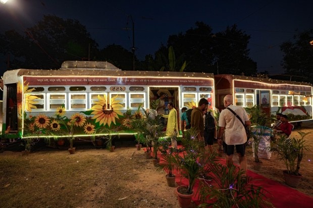 Devotees stand in queue to worship Goddess Durga inside the illuminated tram, in Kolkata. (PTI Photo)